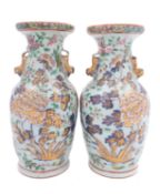 A pair of Chinese Canton famille rose baluster vases with lion-dog handles, painted with peony,