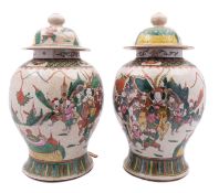A pair of Chinese crackle-glazed baluster vases and domed covers each painted with a processional