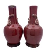 A pair of large Chinese sang de boeuf bottle vases of oviform with raised neck,