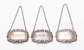 Three silver wine labels.