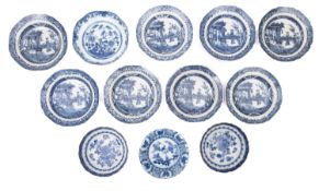 Twelve various porcelain saucer dishes comprising eight painted in blue with figures in a garden