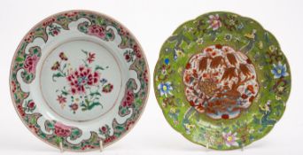 A Chinese famille rose plate and a similar plate with clobbered decoration,