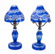 A pair of blue flashed glass table lamps of mushroom shaped form with cut decoration and metal
