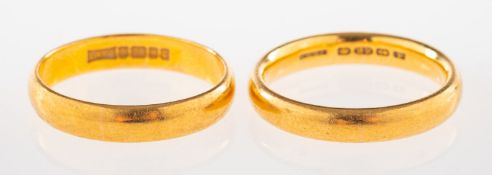 Two 22ct gold wedding bands, both UK hallmark, sizes L1/2 and M1/2, (one slightly misshapen),
