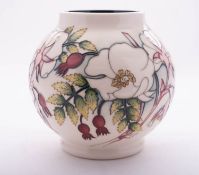 A Moorcroft pottery vase of globular form tube lined in the Wild Rose pattern after a design by