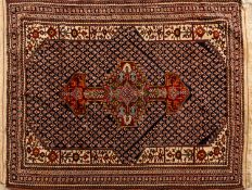 A Quashgai rug, the indigo field with a central rust stepped and pointed medallion,