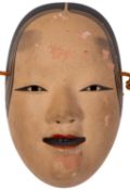 A 20th Century Japanese porcelain mask., having a painted face and cord strap, 22cm long.