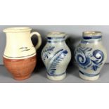 A pair of Rhinish salt glaze jugs, 21 cm, and another partial glazed jug, (3).