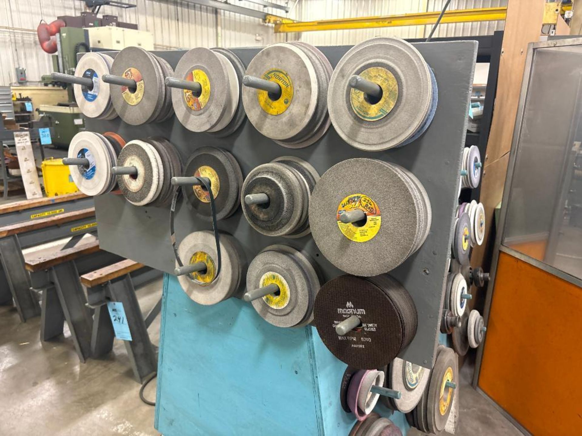 Large Assortment of Used Grinding Wheels on Rack & Wall