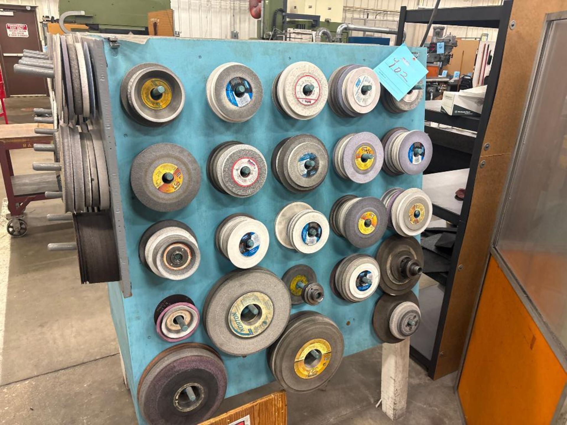 Large Assortment of Used Grinding Wheels on Rack & Wall