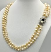 A DOUBLE ROW PEARL NECKLACE WITH A PLATINUM CLASP SET WITH DIAMONDS, PEARLS AND CABACHON