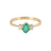 An emerald and diamond three stone ring