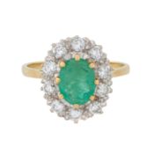 An emerald and diamond halo ring