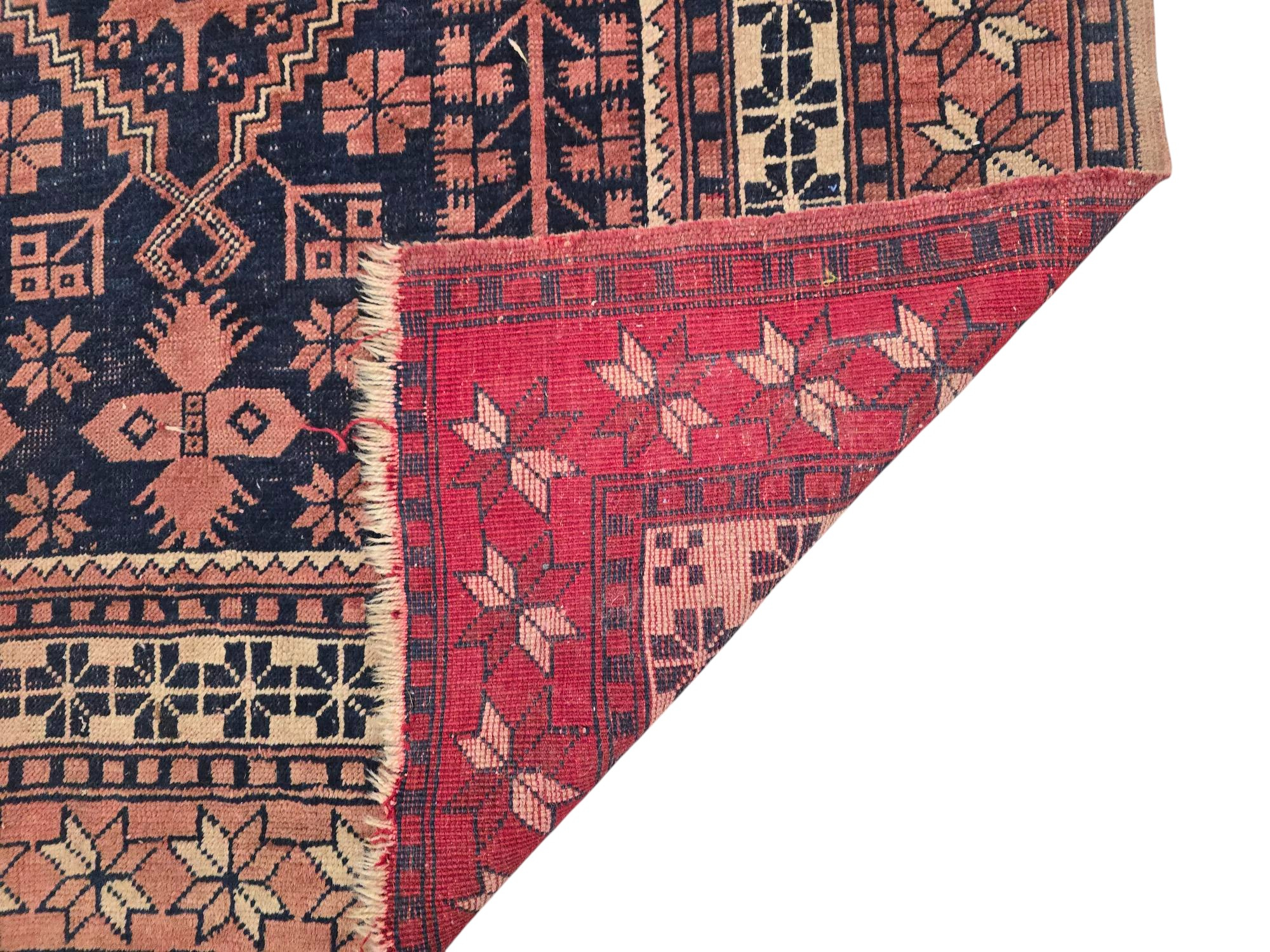 A Persian Baluch rug with geometric pattern on a red ground, 110 by 180cms. - Image 4 of 4
