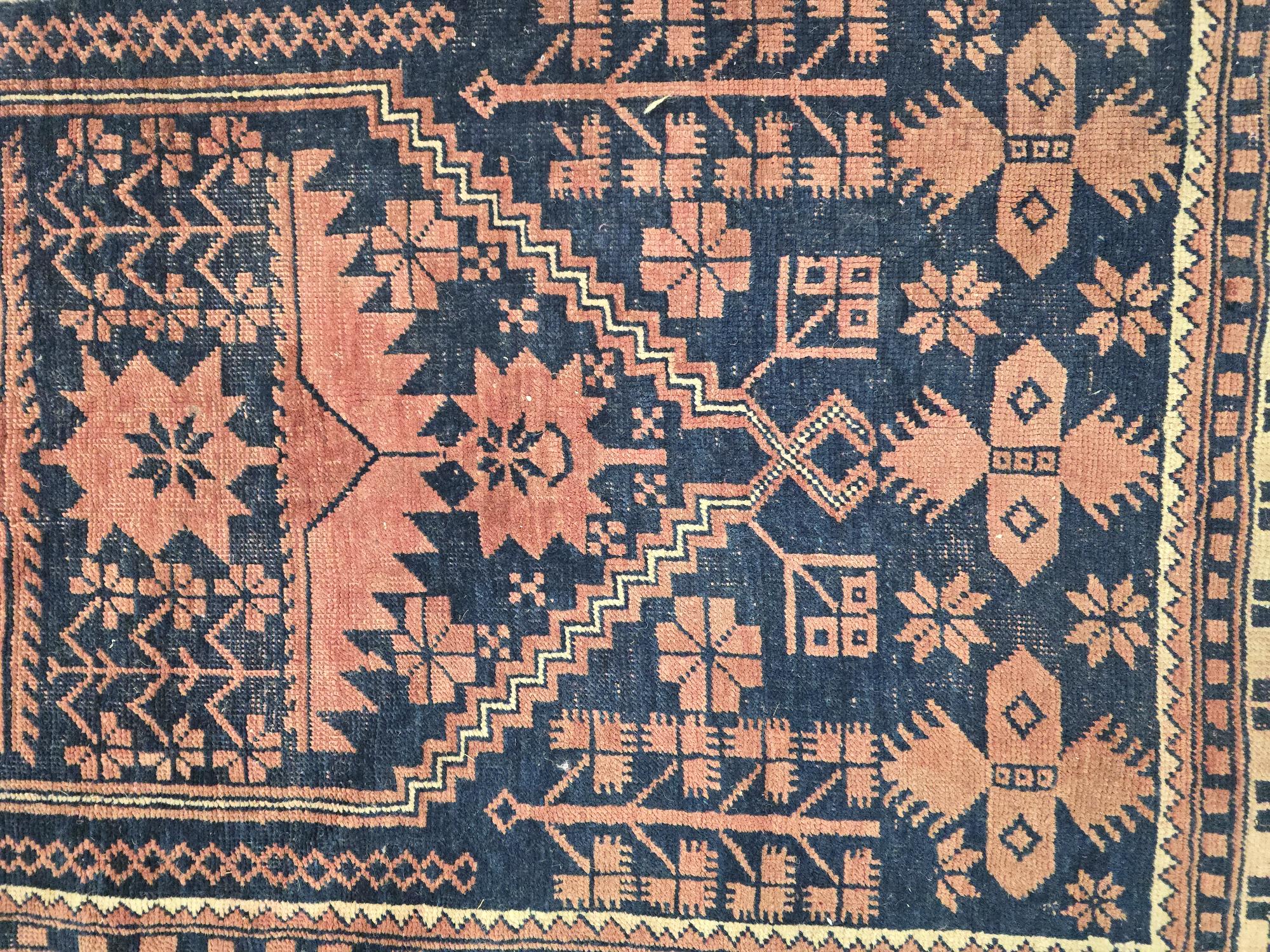 A Persian Baluch rug with geometric pattern on a red ground, 110 by 180cms. - Image 3 of 4