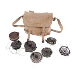 A vintage canvas fishing bag containing various fishing reels to include a J W Young "Trudex"
