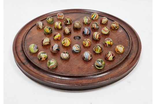 19th / early 20th century mahogany solitaire board on three bun feet, 30cm diameter with 32 German