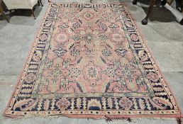 Large pink ground rug with central geometric motif, on geometric and floral field, multiple