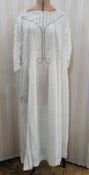 An Edwardian white cotton nightgown with pintuck and lace inserts to the bodice, scoop neck, frilled