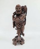 Chinese carved hardwood figure of a standing deity, 20th century, modelled holding a sceptre and a