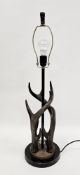 Modern table lamp in the form of two entwined stag horns on a circular base with black finish,