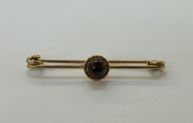 9ct yellow gold bar brooch, having a central cabochon round garnet, in a ropetwist setting, 5.2cm