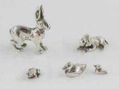 Silver miniature model hare, another dog lying down, a silver-coloured metal miniature frog, duck