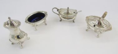 Silver three-piece condiment set with pepperette, salt and mustard, all with gadrooned and shell