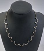 18K white gold and diamond necklace comprising 13 curved sections, the terminations set with 14 claw