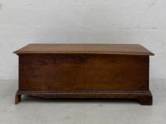 A 19th century oak blanket box or coffer with a thumb moulded lid over a simple carcass raised on