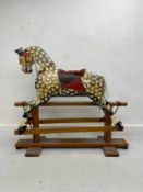 An early 20th century rocking horse, hand painted dapple grey on swing rocking base. 135x152x53cm