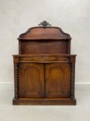 A mid 19th century mahogany chiffonier with shaped carved back above panel doors flanked by