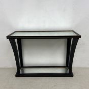 A contemporary ebonised Empire style console table with faux aged glass to the top and undertier.