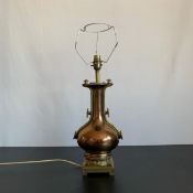 A 20th century gilt metal table lamp having a fluted rim over an urn or vase form body flanked by