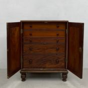 A Georgian mahogany cabinet with panel doors enclosing drawers raised on turned supports. H.108 W.83