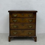 An early Georgian walnut featherbanded bachelor's chest of small size with foldover top above four