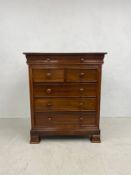 A Victorian style teak chest of drawers with frieze drawer above two short and three long drawers on