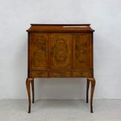An early 20th century walnut cabinet with Dutch marquetry style inlay, folding panel door above
