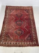 A Shiraz carpet with triple central pole medallions with stylised flowerhead motifs across the