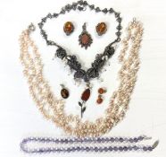 A collection of silver costume jewellery including a three string pearl necklace, purple beads