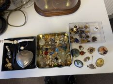 A mixed collection of costume jewellery to include hand painted brooches etc.