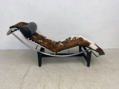 A Le Corbusier style LC4 chaise in leather and cowhide upholstery on a blackened aluminium and