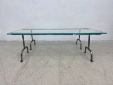 A contemporary dining table with heavy plate glass top on wrought iron trestle supports. H.42 W.