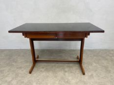 A mid century Cassina writing table with black plate glass top above frieze drawers on metal clad
