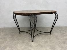 An wrought iron occasional table with tree cross section top. H.71 W.105 D.92cm.