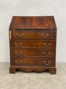 A Georgian style mahogany writing bureau with gilt and tooled green leather lined fall front