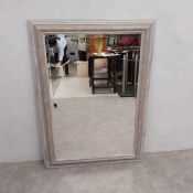 A contemporary wall mirror with bevelled plate in a distressed frame. H.108 W.76.5cm