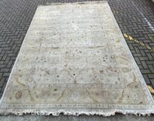 A large Turkish Oushak carpet with allover scrolling foliate decoration in muted colours over a