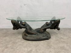 A vintage coffee table with oval plate glass top raised on a bronzed composite resin figural mermaid