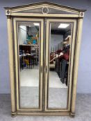 A 19th century French Empire painted armoire or wardrobe with shaped pediment over mirrored doors
